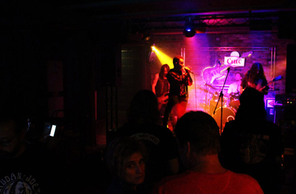 A band performing on stage in front of a crowd.