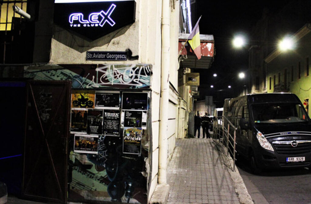 A man walking down the street in front of a building.