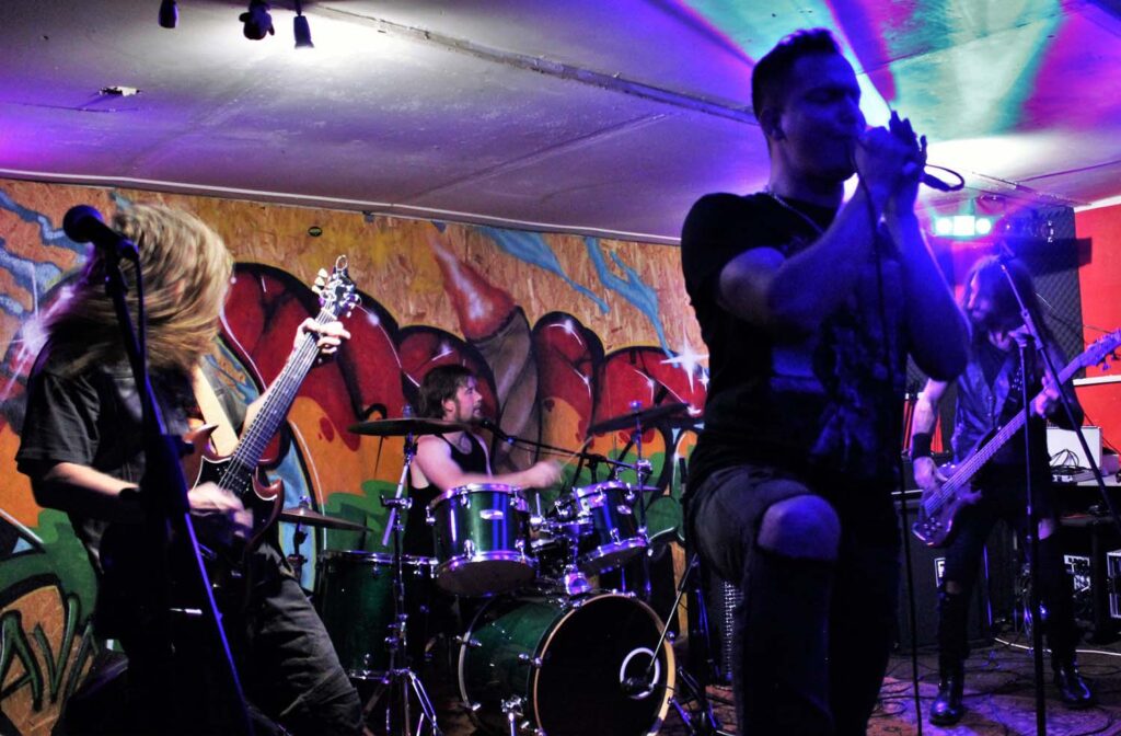 A band performing in front of a mural.