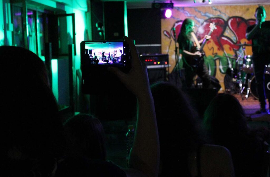 A person taking a picture of someone on stage